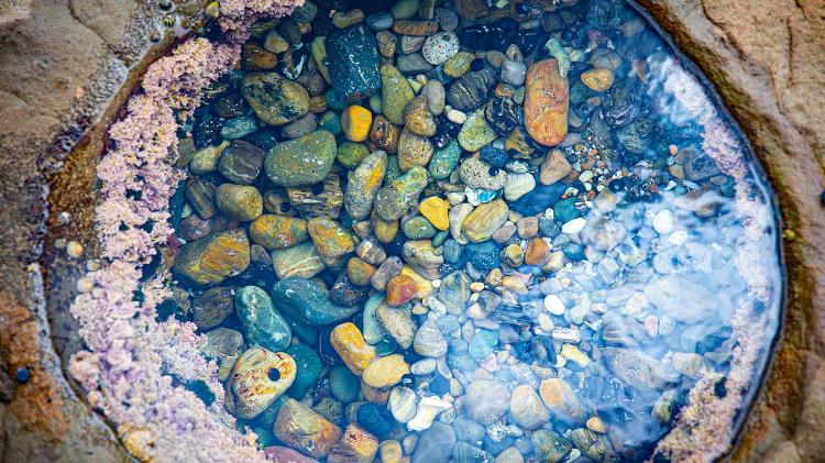 Birdseye view of rock puddles filled with stones and water
