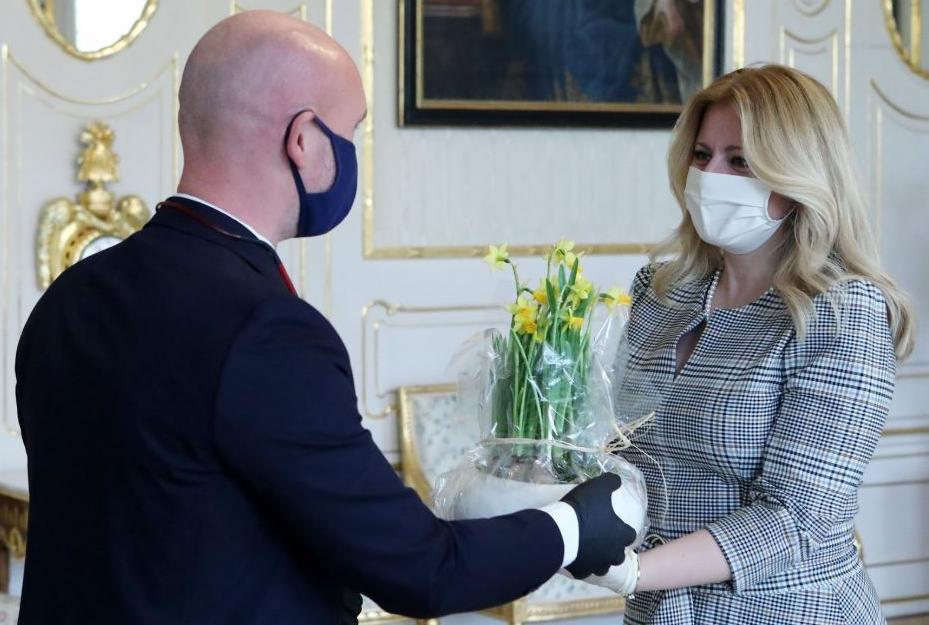 The Slovenian president wearing a face mask while shaking a man's hand