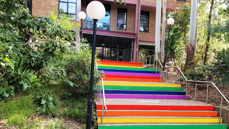 A stairway painted in various colours leads up to a building.