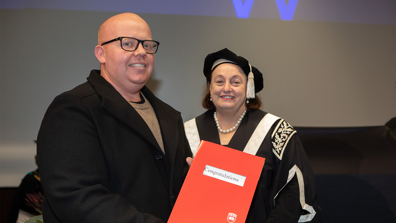Zach Pettit is accepting a UOW College graduate certificate from Vice Chancelor Patricia Davidson