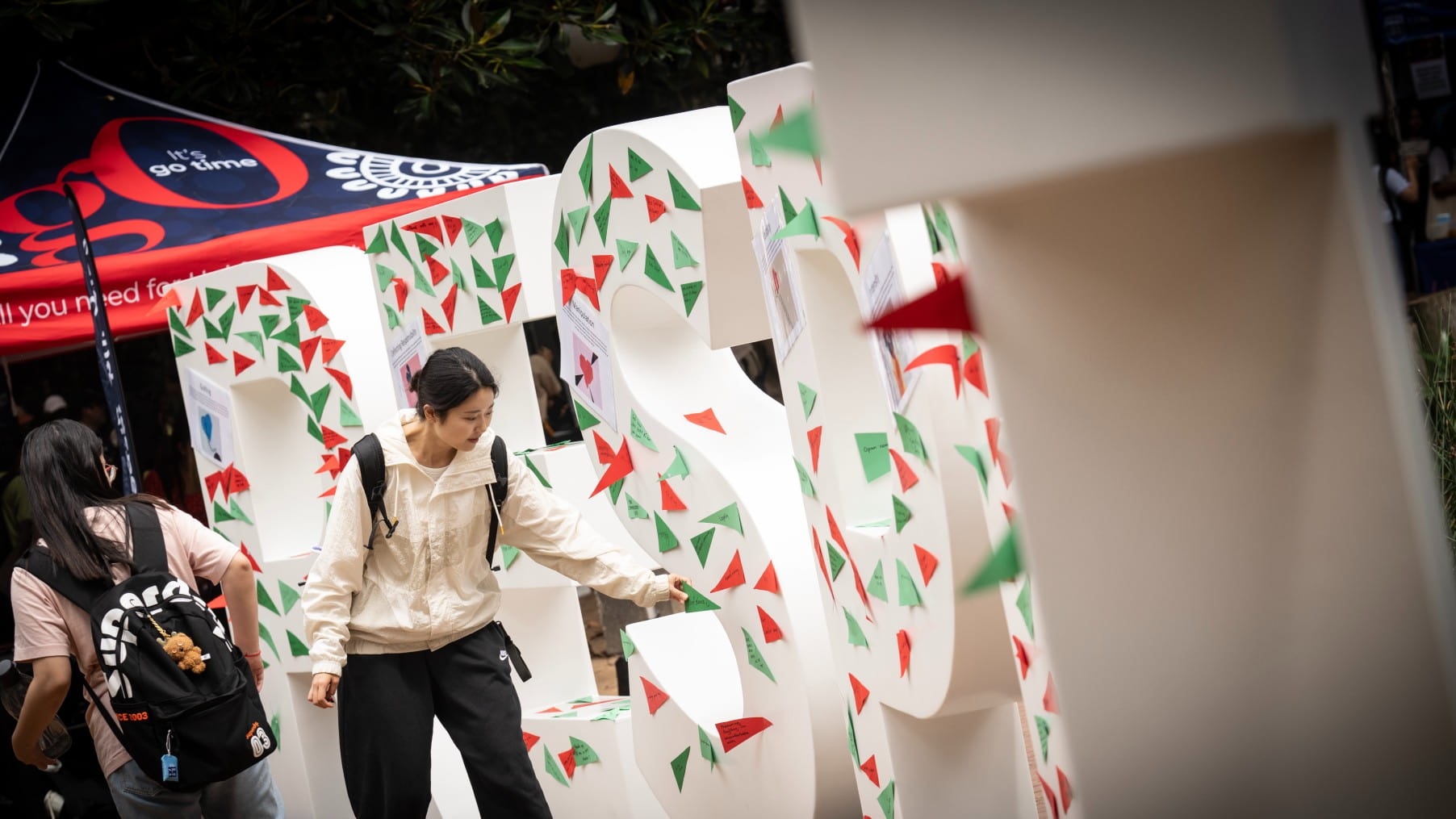 A student pins a flag to the large white Respect letters at UOW. Photo: Paul Jones