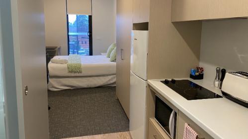 Room with kitchenette and bed with a window