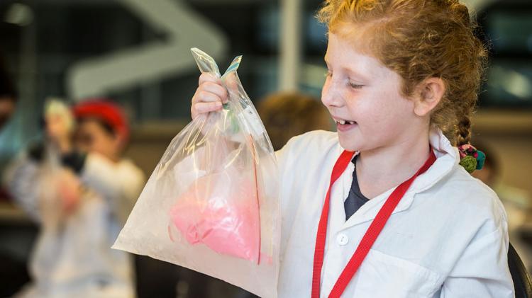 Child looking excitedly at plastic bag with ice
