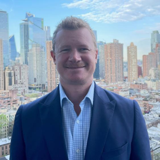 UOW graduate Cameron Poulton smiling at camera with New York City skyline in background