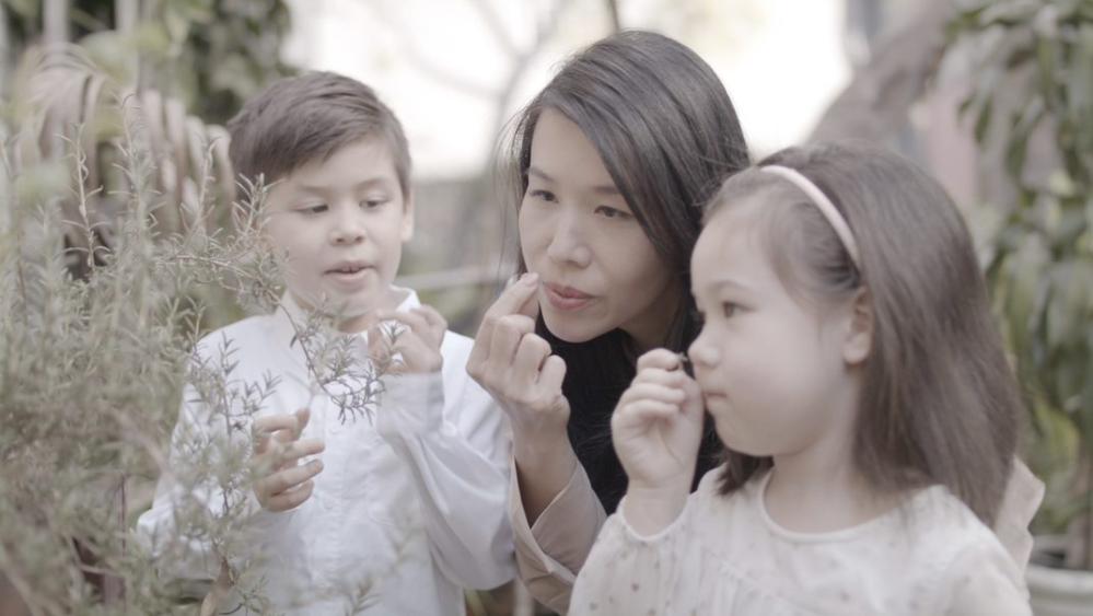 Amanda and her children smelling flowers