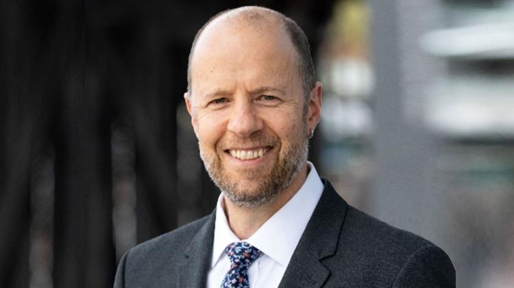 Bradley Williams smiling, the background is blurred.