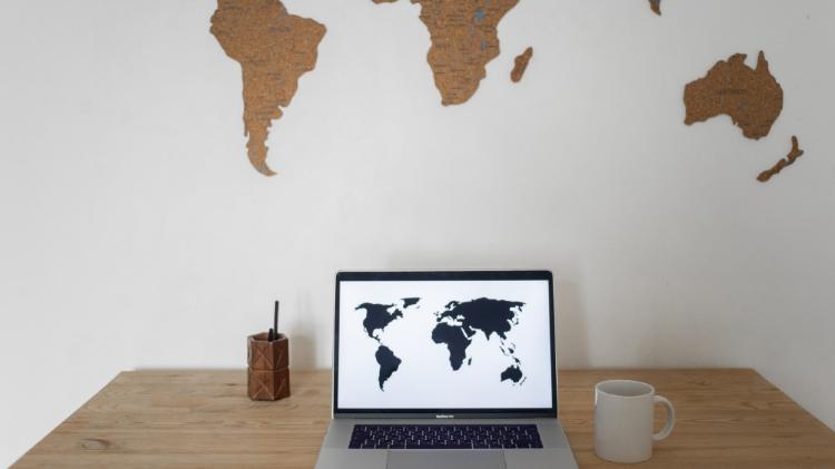 World map on laptop screen and wall