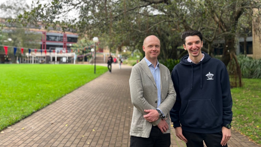 Associate Professor Matt Pepper with current UOW student, Louis Angeli.standing outside on a pathway.