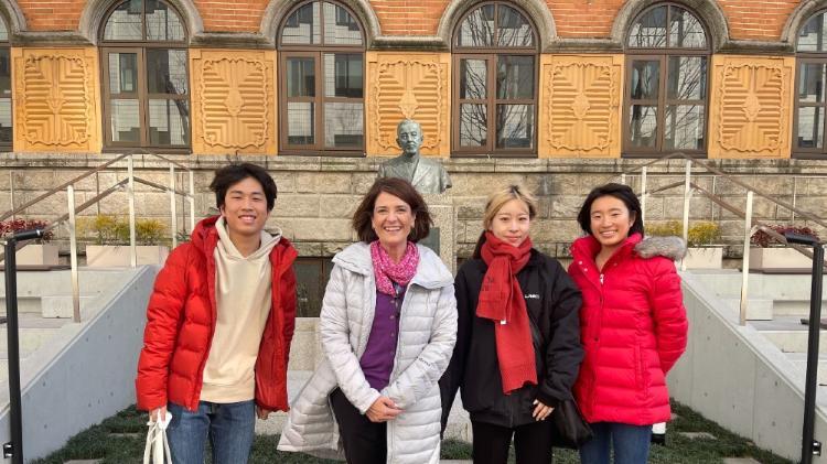 Dr Oriana Price standing outside a building with staff of Sophia University in Tokyo