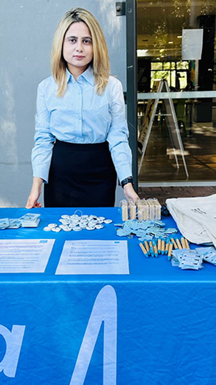 Woman stands at a stall table with Bupa items and branding displays.