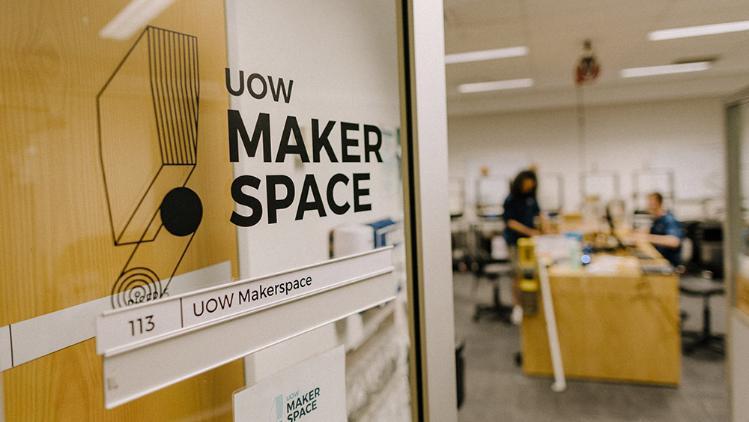 Opened door with Makerspace logo, leading into the workshop