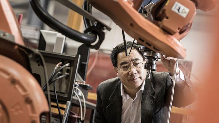 Huijun Li in the FIF lab, looking at equipment