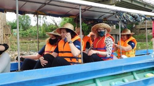 People in a river boat wearing orange life jackets.