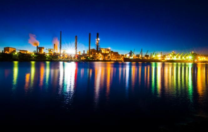Port Kembla Steelworks at night, with the bright lights reflecting on the water