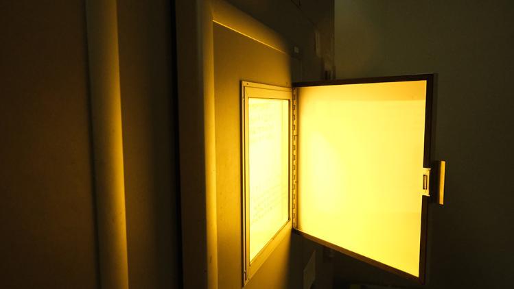 Yellow light appearing from an open wall safe door.