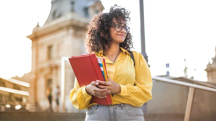 Lady in yellow shirt holding books