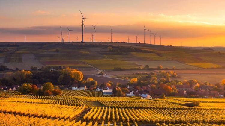landscape image of rolling hills, farmland and wind turbines