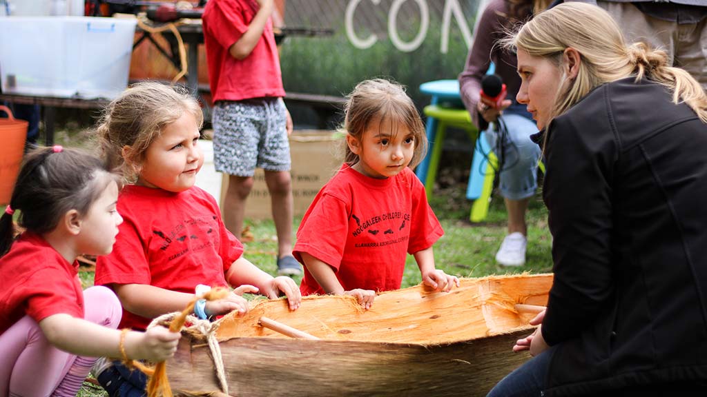 Children playing with bark-canoe