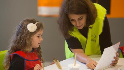 Early start volunteer engaging with child through art