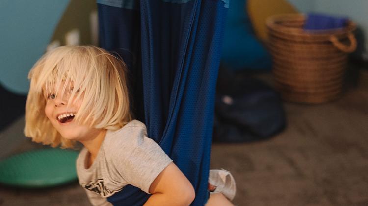 Young child swinging on blanket