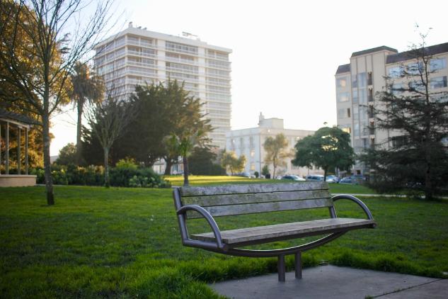 Lone park bench in middle of park in city