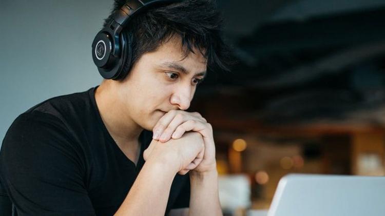 Student sitting at laptop with headphones on