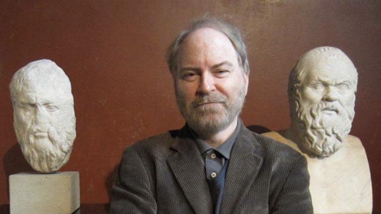 Philosopher Shaun Gallagher in a photo with two statues of heads