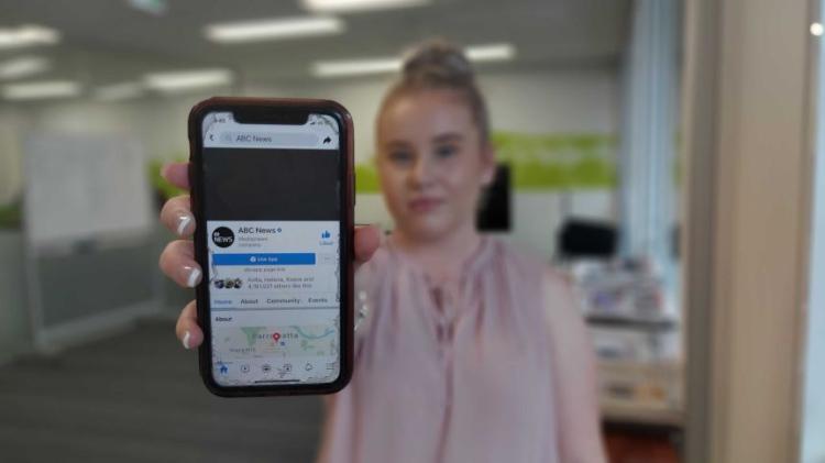 Maddie Date holding phone to camera - ABC Illawarra image