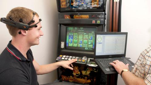 Student with research equipment on head looking at compuer screen