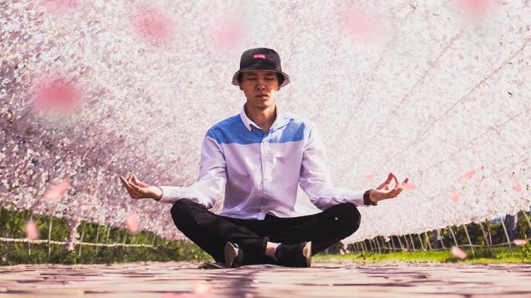 Man meditating under a jasmine tunnel