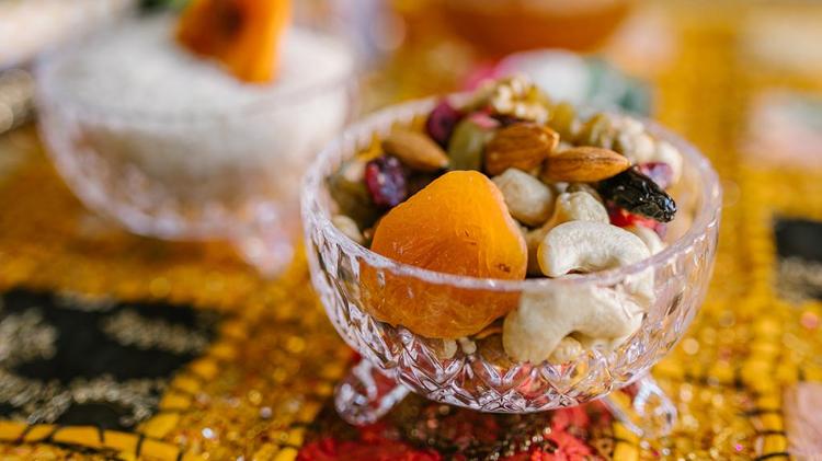Glass bowl of nuts and dried fruit on table