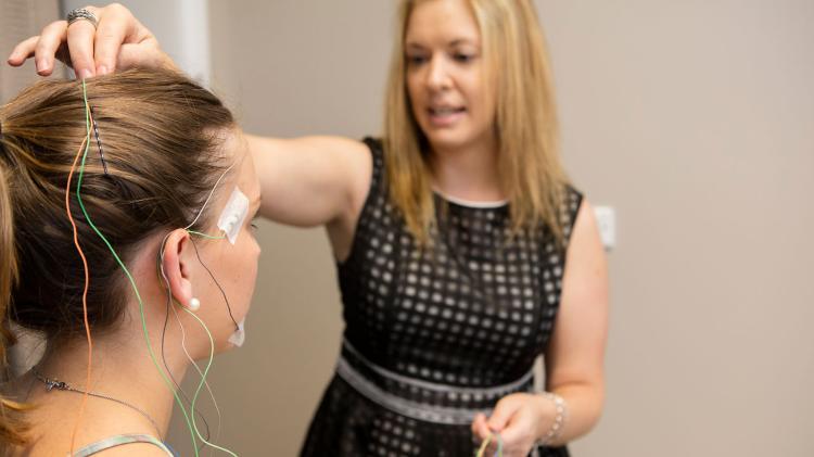 Sarah Loughran placing electrodes on student's head for sleep test