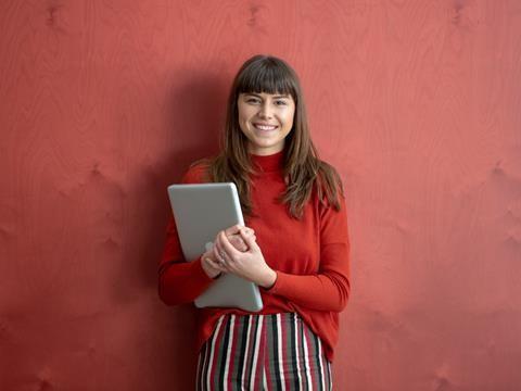 Juliet Gobran standing holding laptop