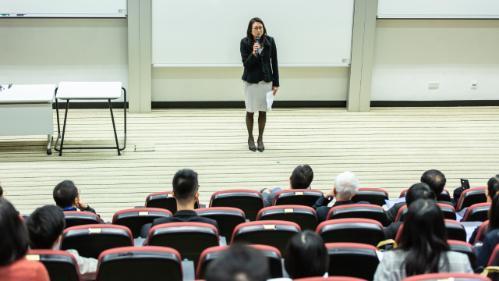 Woman holding microphone in front of lecture