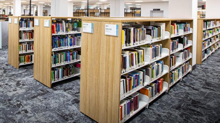 Library shelving with books available to borrow