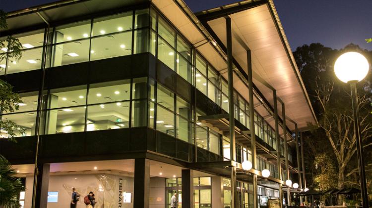 The Wollongong Campus Library lit up at night, shown from the outside