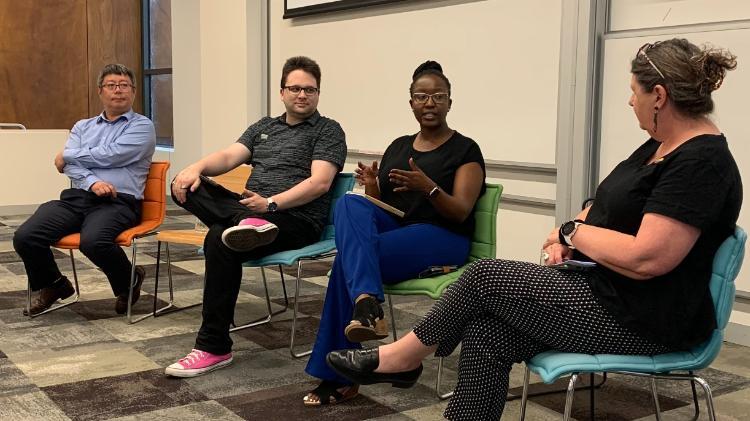 Four people sitting in chairs talking