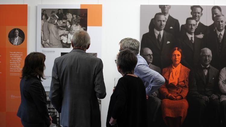 A group of four people viewing photographs at the Blaze exhibition