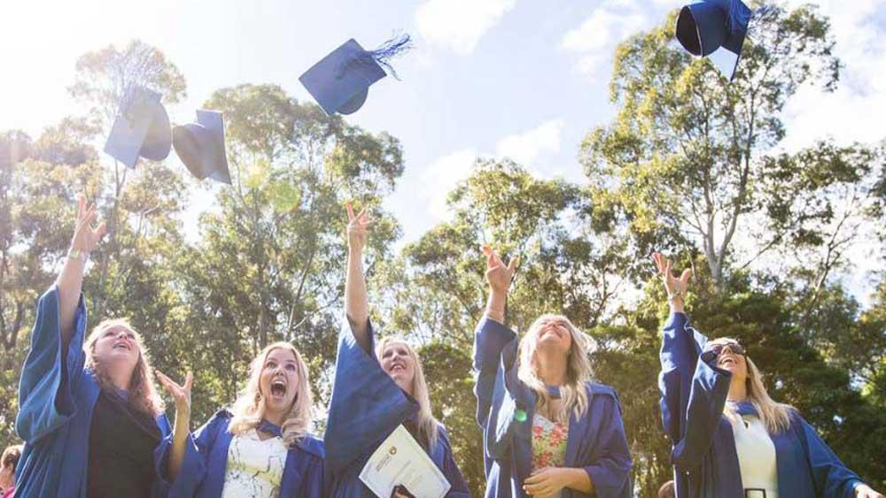 Students tossing their graduation hats into the air celebrating