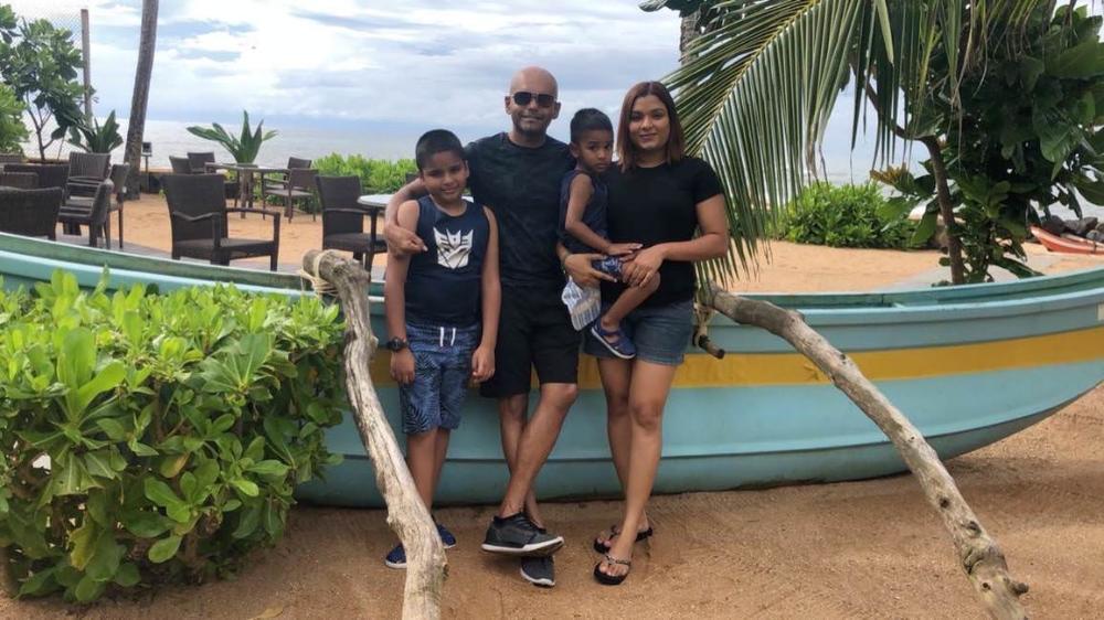 Adham and his family sitting on a boat under a tree