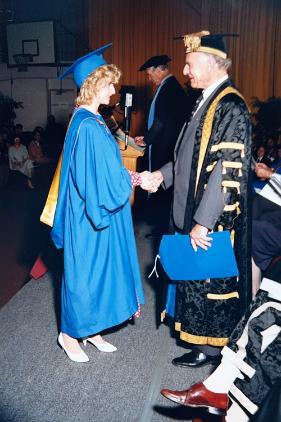 Deborah posing at graduation with the Vice Chancellor