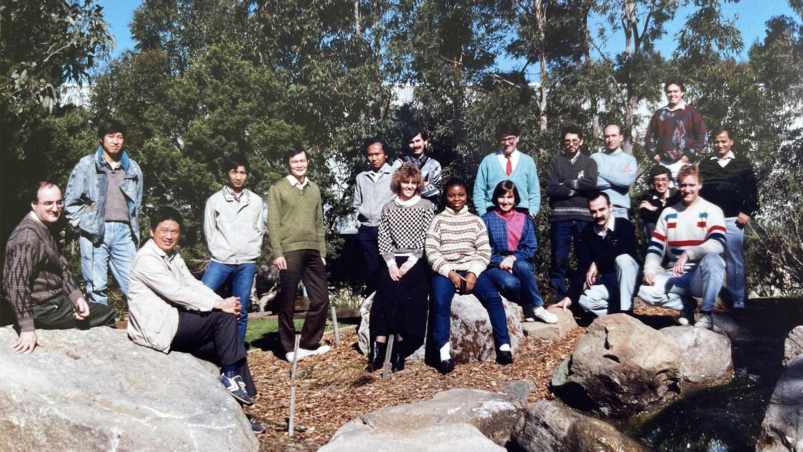 A group of students are sitting on rocks in a garden at UOW in the 1990s