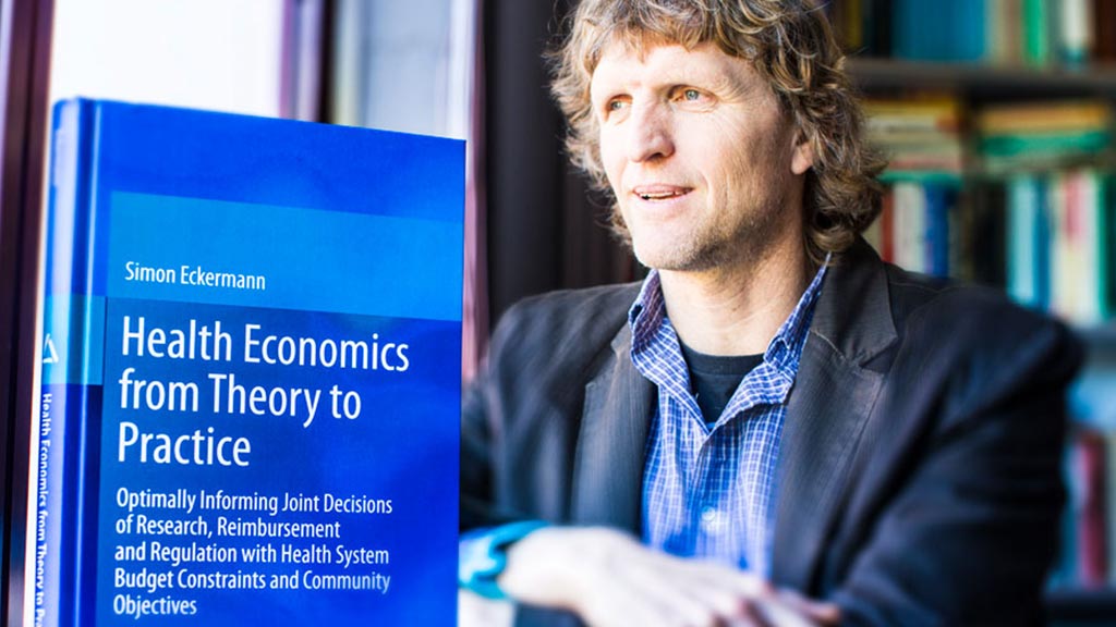 Simon Eckermann sitting with his Health Economics book