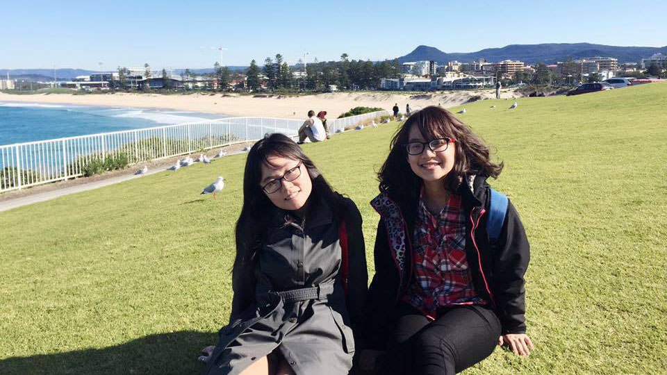 Two students enjoy the sun at City Beach, Wollongong