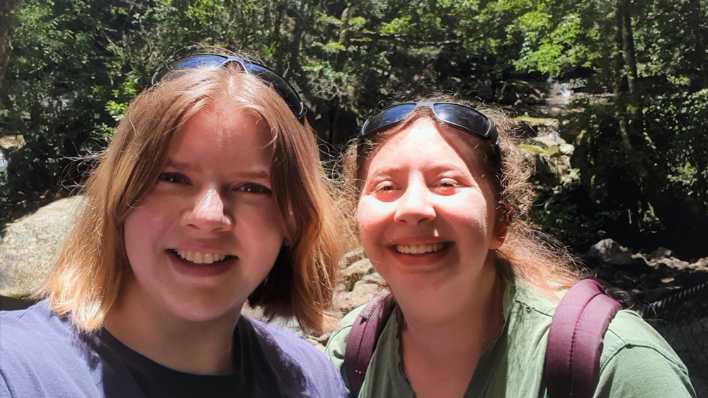 UOW student Carrin Goosen takes a selfie with her friend. They are smiling at the camera.