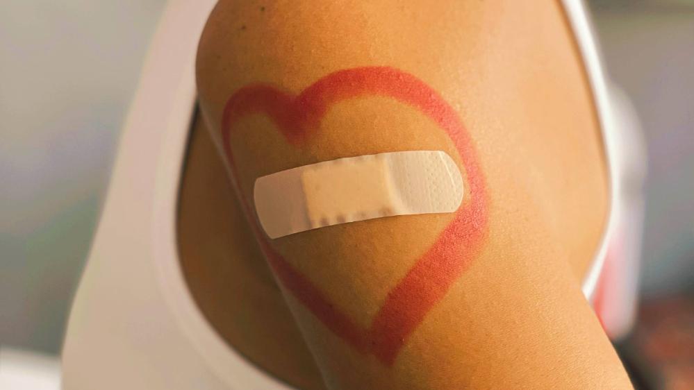 image of band aid on woman's arm with love heart drawn around