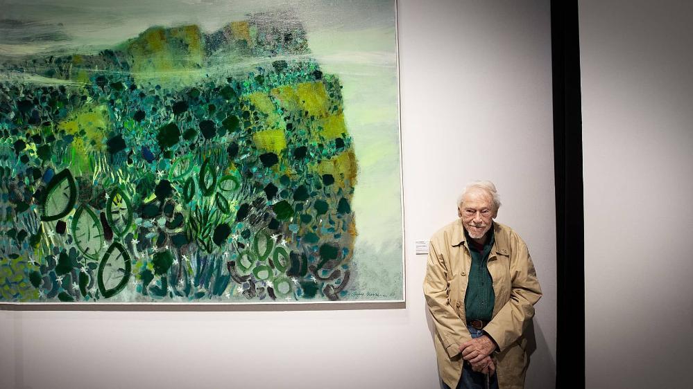 Guy Warren stands in front of a work of art in a gallery at UOW. Photo: Paul Jones