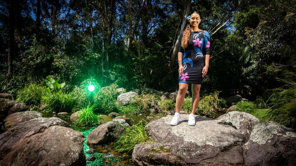 Moemoana Schwenke pictured on a rock, with a background of trees, at UOW. Photo: Paul Jones