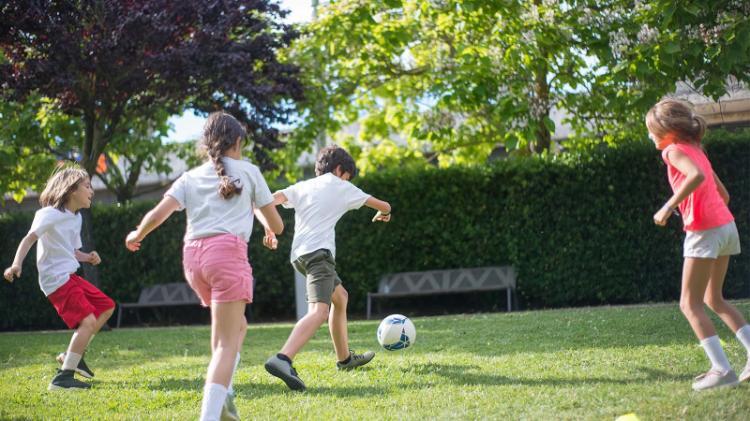 Children playing soccer in a park