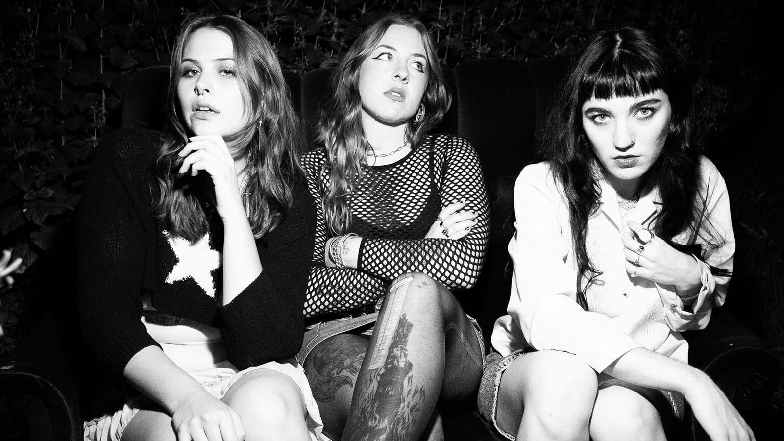 A black adn white image of three young women sitting on chairs